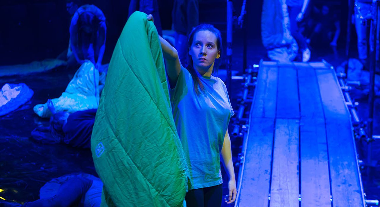A girl holding a green sleeping bag