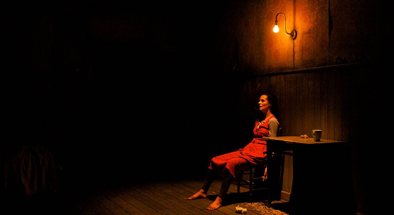 A woman in a red dress sat under a warm light