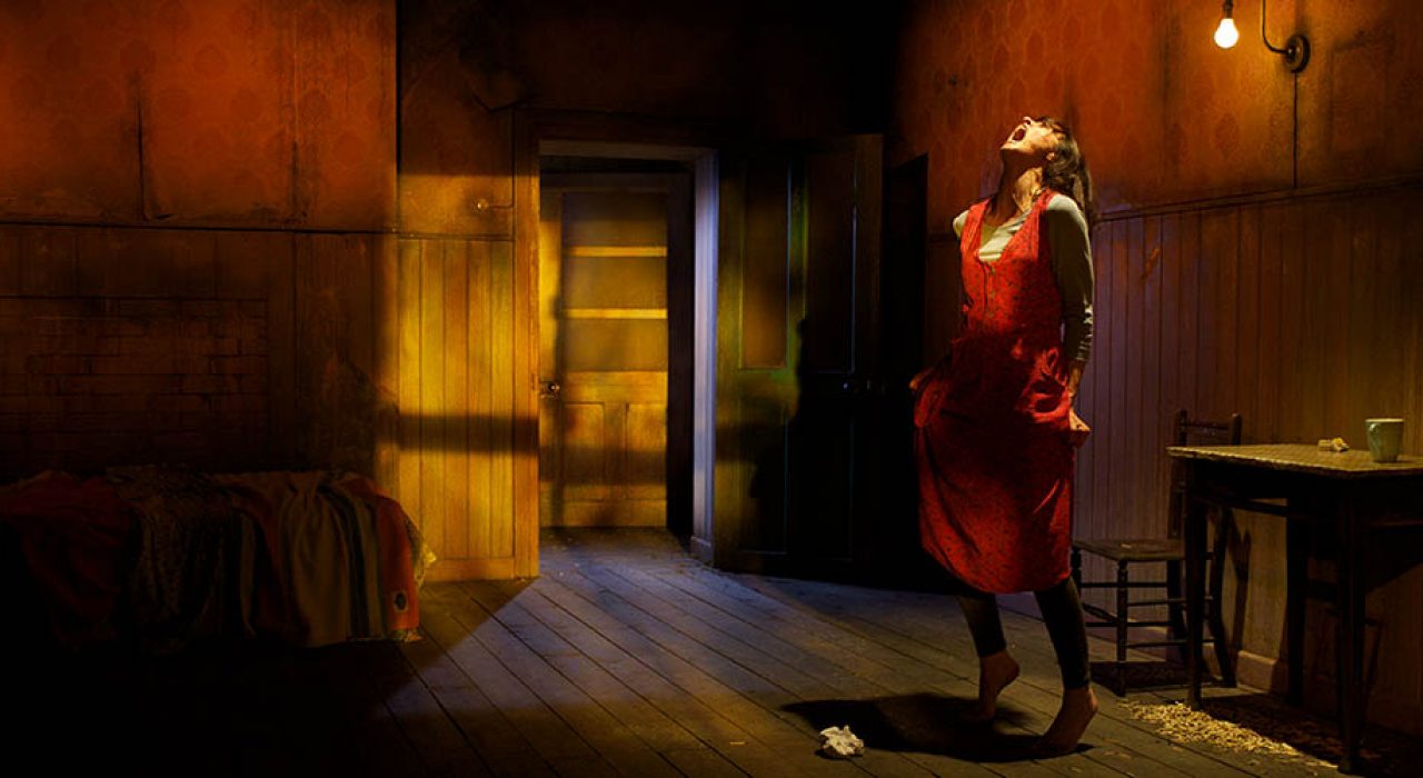 A woman in a red dress stood in a warm lit room