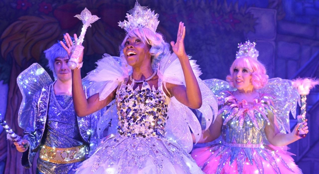 Three fairies wearing glittery sequin dresses and feather crowns