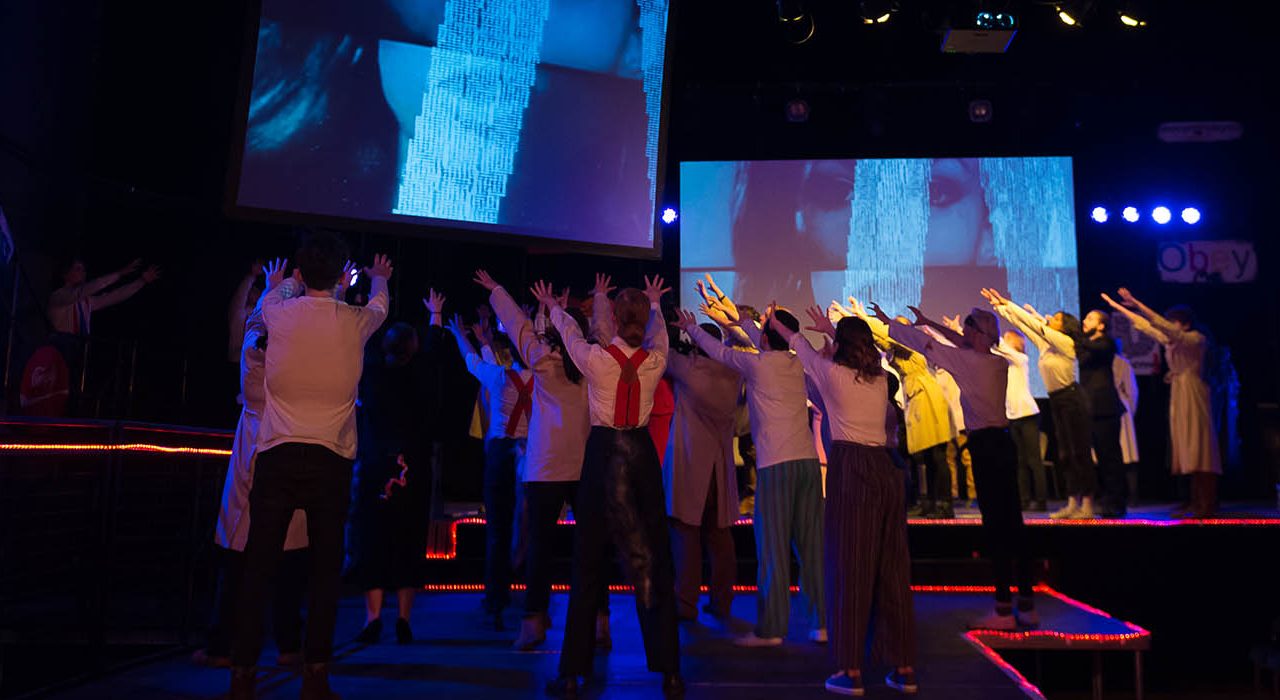 A crowd of people worshipping a screen