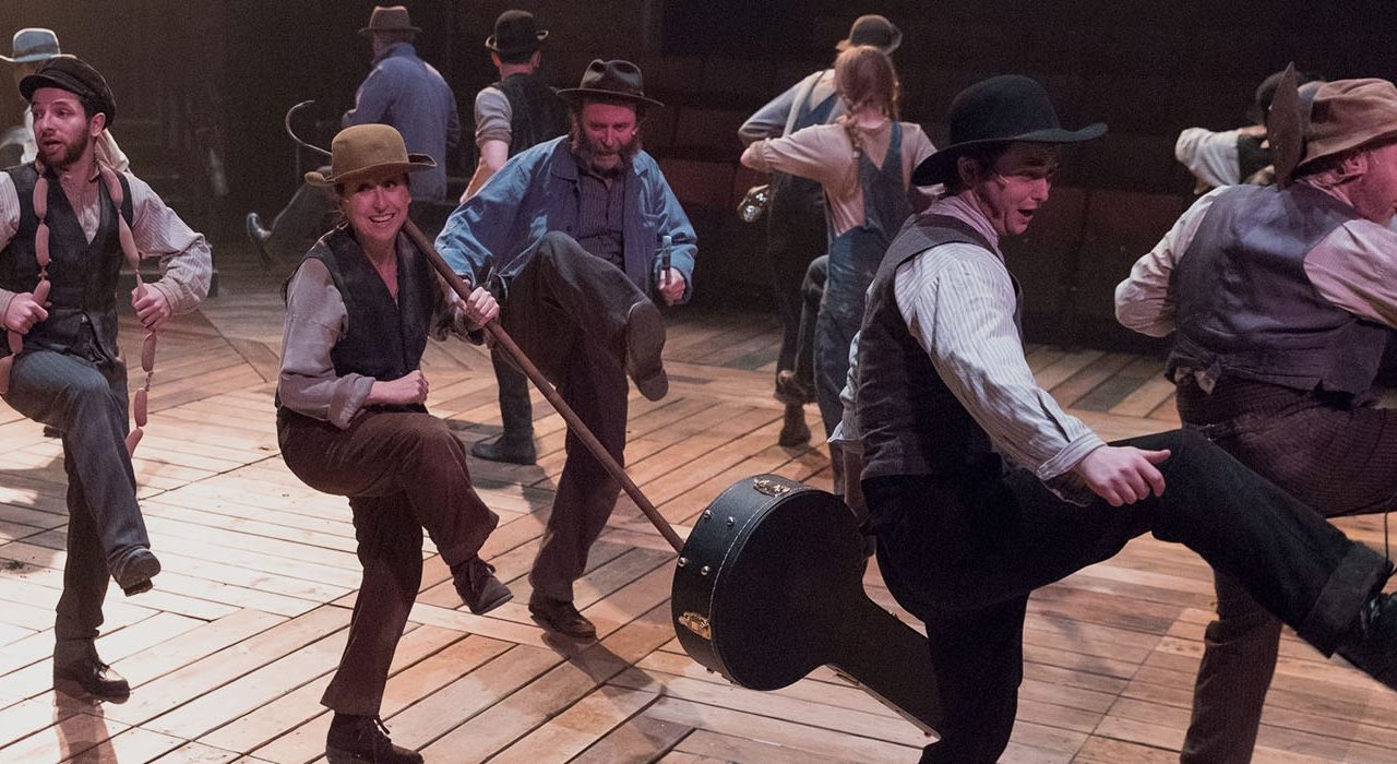 A group dancing dressed in shirts waist coats and hats