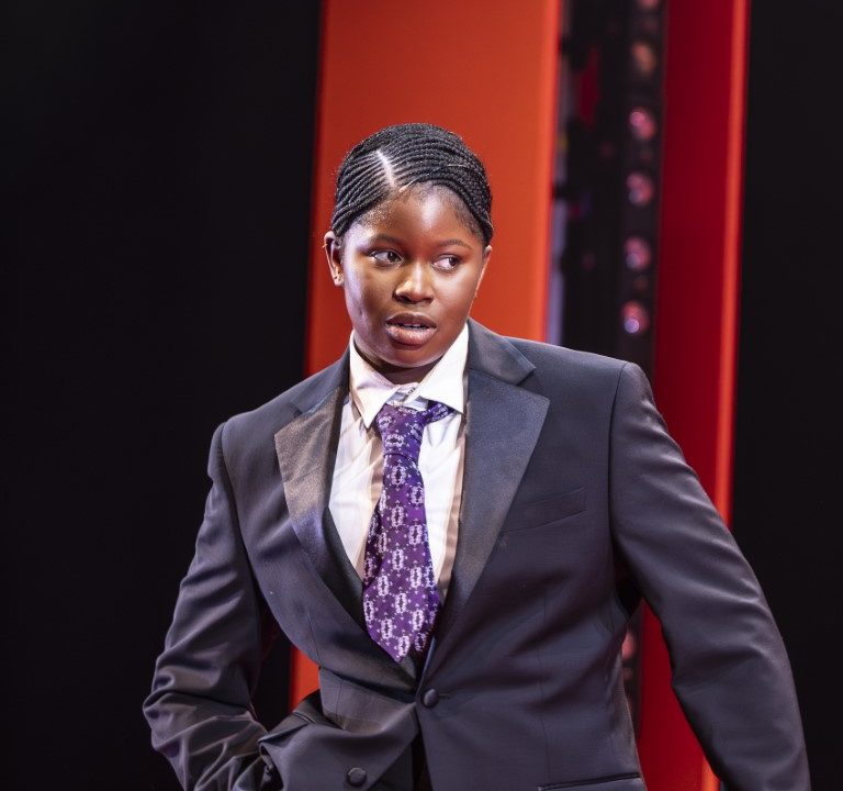 A person wearing a suit with a purple tie holding a brief case